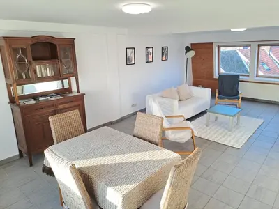 a living room with a couch and a table and chairs at De Peperbus in Lokeren