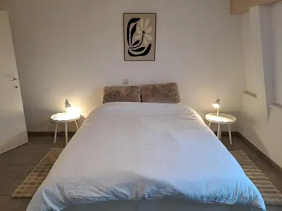 a bedroom with a large bed with two tables at De Peperbus in Lokeren