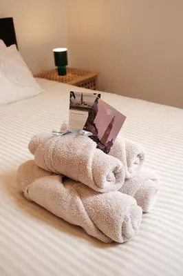 a pile of towels sitting on top of a bed at Cozy Parisian-Style Flat in Antwerp Zuid in Antwerp