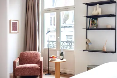 a living room with a chair and a window at Le Catherine by Sweett in Brussels