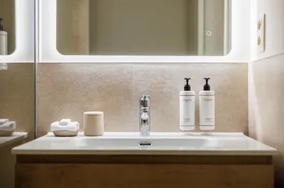 a bathroom with a sink with two bottles on it at Le Catherine by Sweett in Brussels