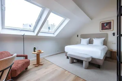 a bedroom with a white bed and a window at Le Catherine by Sweett in Brussels