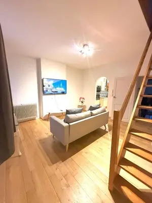 a living room with a couch and a staircase at EU District Loft in Brussels
