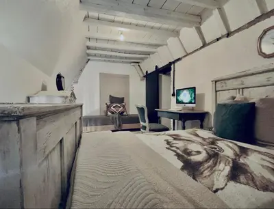 a bedroom with a large bed and a desk at The Mystical Suite in Antwerp