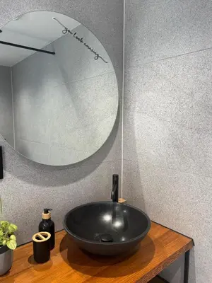 a bathroom with a black sink and a mirror at B&B Wellness Garden in Herzele