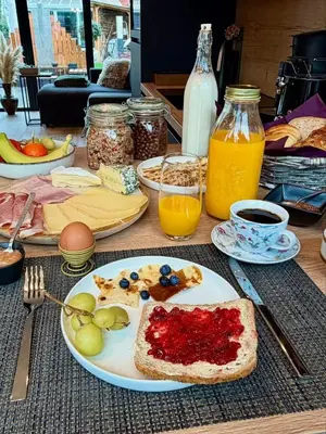 a table with a plate of breakfast food on it at B&B Wellness Garden in Herzele