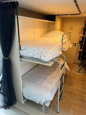 two bunk beds in a room with a curtain at B&B Wellness Garden in Herzele