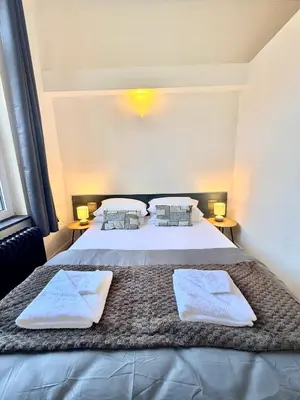a bedroom with a large bed with towels on it at Schuman Square Residence in Brussels