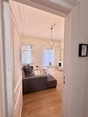 a living room with a bed and a dining room at Schuman Square Residence in Brussels