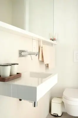 a white bathroom with a sink and a toilet at Luxurious 1BR Apartment with Parking in Antwerp