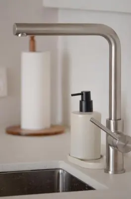 a sink with two rolls of toilet paper next to a faucet at Luxurious 1BR Apartment with Parking in Antwerp