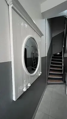 a mirror on a wall in a room with a staircase at Appartement Bruxelles 1 in Brussels