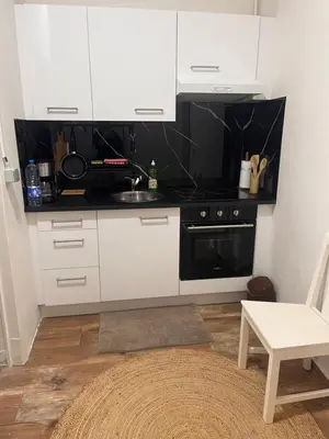a kitchen with white cabinets and a sink at Appartement Bruxelles 1 in Brussels