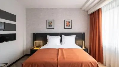 a bedroom with a large bed with orange sheets at Sunset Paradise Tomorrowland hotel and transport at Hyllit Antwerp in Antwerp