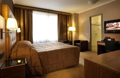 a hotel room with a bed and a television at Sunset Paradise Tomorrowland hotel and transport at Hyllit Antwerp in Antwerp