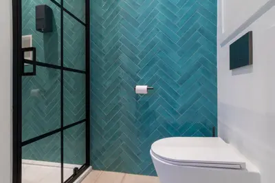 a bathroom with a toilet and a blue tiled wall at heartatd'Anvers Original in Antwerp