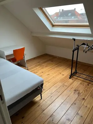 a bedroom with a bed and a desk and a window at Kamer Demer in Aarschot
