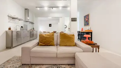 a living room with a couch and a kitchen at Cosy loft near City Centre, Terra CasaMia in Antwerp