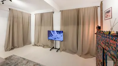 a living room with curtains and a flat screen tv at Cosy loft near City Centre, Terra CasaMia in Antwerp