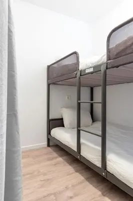 a bedroom with two bunk beds and a wooden floor at Apartment over two floors for 5 guests near Midi & Grand Place in Brussels