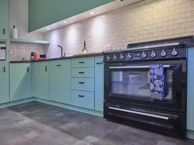 a kitchen with blue cabinets and an oven at Lierelodge in Oud-Turnhout
