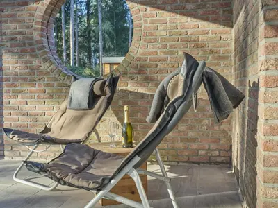 two chairs and a table with a bottle of wine at Lierelodge in Oud-Turnhout