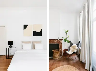 a white bedroom with a bed and a fireplace at The Collector's House in Antwerp