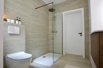 a bathroom with a toilet and a glass shower at Hip apartment between South & Historic Antwerp in Antwerp