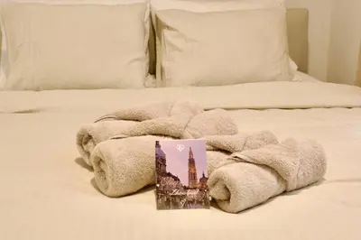 a towel on a bed with a picture of a building at Hip apartment between South & Historic Antwerp in Antwerp