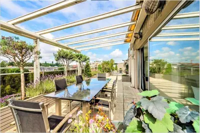 a patio with a long table and chairs on it at Vaste et somptueux appartement à Bruxelles in Brussels
