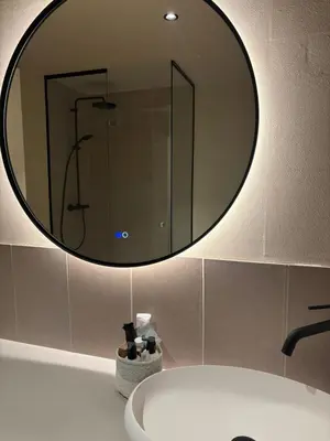 a bathroom with a large mirror above a sink at Spacious luxurious 1 bedroom stay in the city center in Antwerp