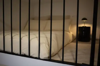 a bed with white sheets in a room at Charmant studio avec mezzanine et terasse in Brussels