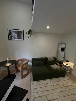 a living room with a green couch and a table at Charmant studio avec mezzanine et terasse in Brussels