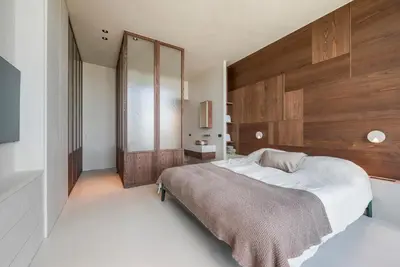 a bedroom with a large bed and a wooden wall at Montevideo Penthouse in Antwerp