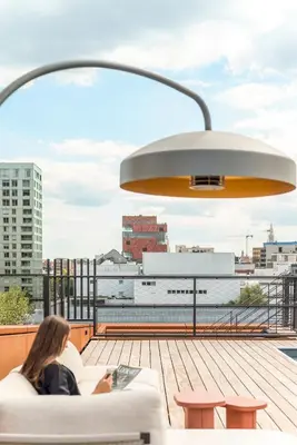 a woman sitting on a couch on a roof at Montevideo Penthouse in Antwerp