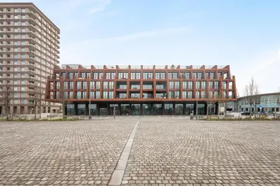 a large brick building in front of two tall buildings at Montevideo Penthouse in Antwerp