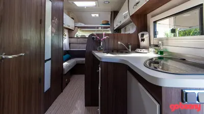 an rv bathroom with a sink and a mirror at Camper max 5p, unique experience, terras, central Belgium in Denderleeuw