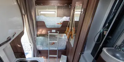 a small room with two bunk beds in an rv at Camper max 5p, unique experience, terras, central Belgium in Denderleeuw