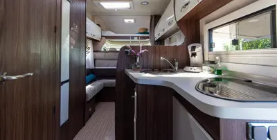 an rv bathroom with a sink and a mirror at Camper max 5p, unique experience, terras, central Belgium in Denderleeuw
