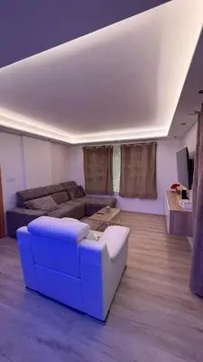 a living room with a blue couch and a tv at Villa aux portes de Bruxelles in Dilbeek