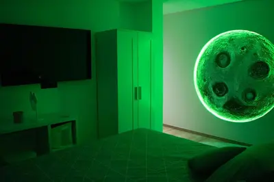 a green room with a bed and a green orb on the wall at Villa aux portes de Bruxelles in Dilbeek