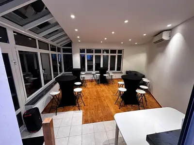 a room with bar stools and tables and windows at Villa aux portes de Bruxelles in Dilbeek