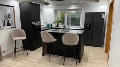 a kitchen with a counter and two stools in it at Villa aux portes de Bruxelles in Dilbeek