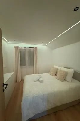 a white bedroom with a large bed with white pillows at Villa aux portes de Bruxelles in Dilbeek