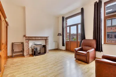 a living room with a chair and a fireplace at Vanderdussen in Brussels