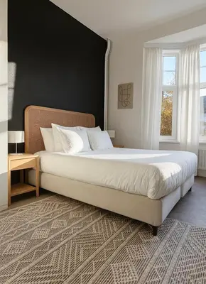 a bedroom with a large bed with a black wall at Modern 2-Bedroom Apartment for 4 Guests, In a Prime Location Close to the Train Station and the Historic Center of Ghent in Ghent