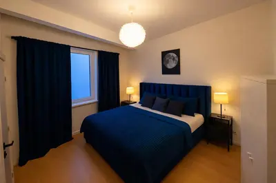 a bedroom with a blue bed and a window at Brussels City Fresh Oasis in Brussels