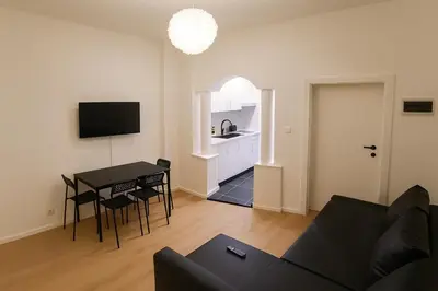 a living room with a couch and a table and a kitchen at Brussels City Fresh Oasis in Brussels