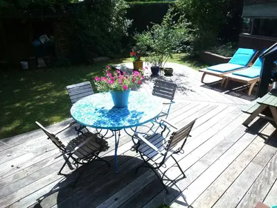 a table with chairs and flowers on a wooden deck at Villa West heaven Valley Gent in Ghent