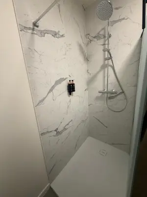 a bathroom with a shower with a white marble wall at Business Accommodation Mol Centre in Mol